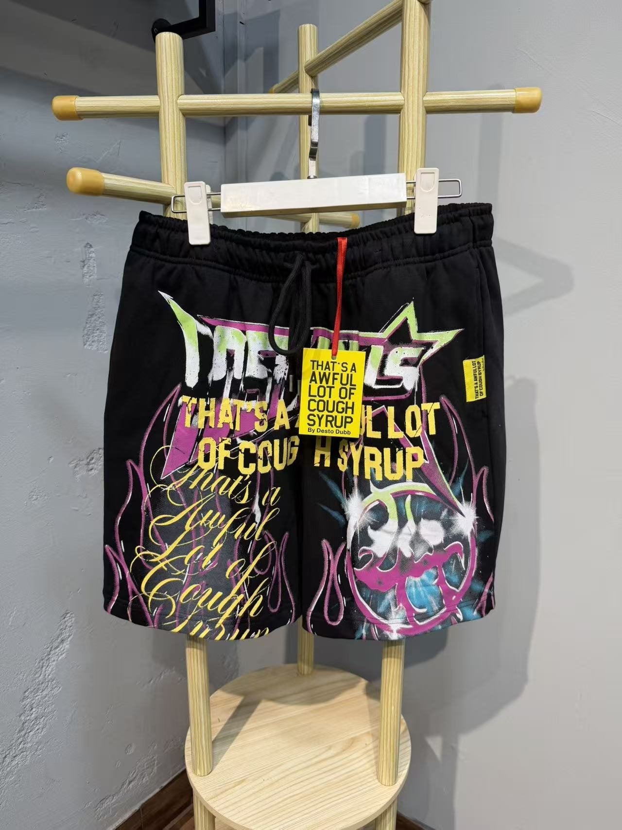 THAT'S A AWFUL LOT OF COUGH SYRUP Black Graphic Drawstring Shorts — front